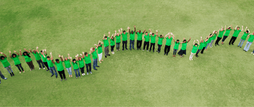 aerial shot of long line of people in green t-shirts celebrating sustainable apparel